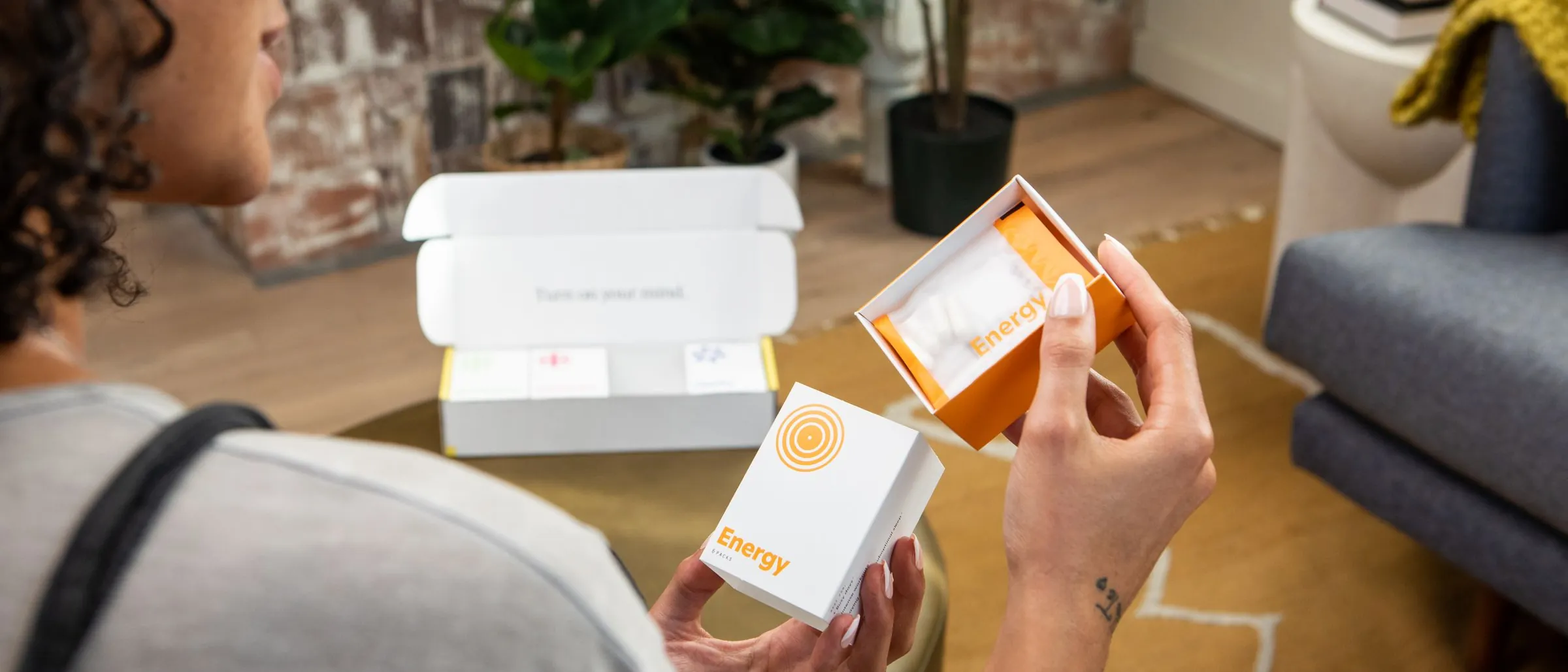 A woman unboxing a delivery of supplements at home.