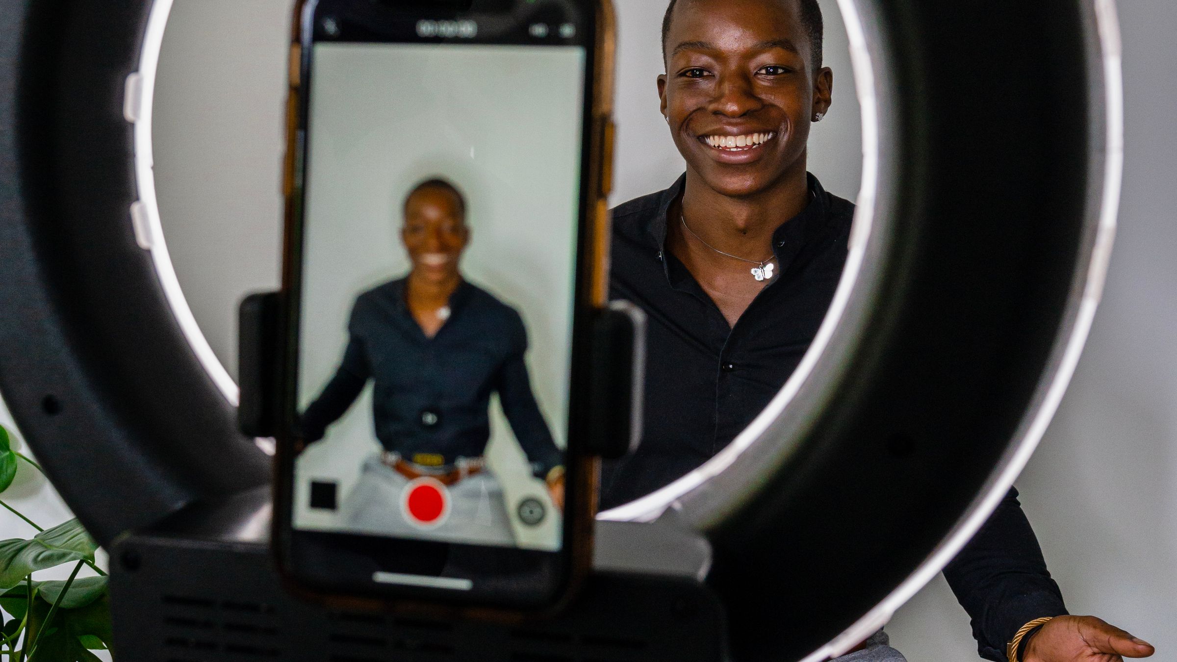 Creator filming content on a phone with a ring light